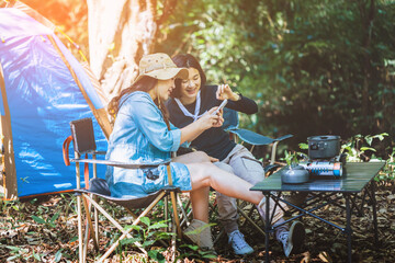 Happy two female relaxing taking with smartphone and camping summer holidays. People Friendship