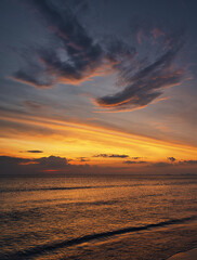 Fototapeta premium Beautiful sand beach, angel wings shape clouds in the sky during a dramatic sunset and a yacht on the sea with waves - Koh Lanta Thailand