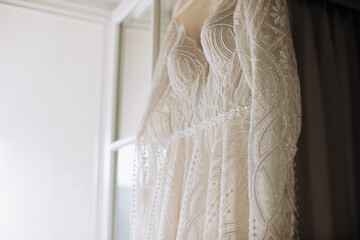 Beautiful lace wedding dress for the bride in a hotel room. Wedding morning