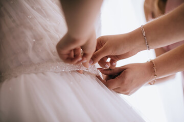 Obraz na płótnie Canvas Bridesmaid Helping Bride With Dressing In Bedroom