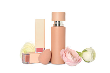Bottle of perfume, lipsticks, makeup sponge and ranunculus flowers on white background
