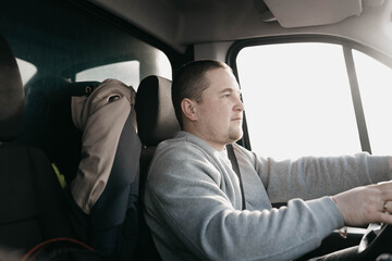 a male truck driver is driving, a young european man.
