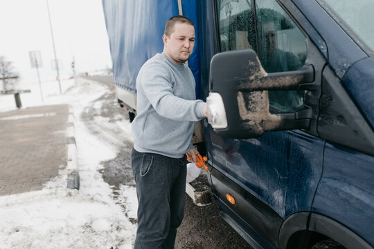 a man truck driver cleans windows.