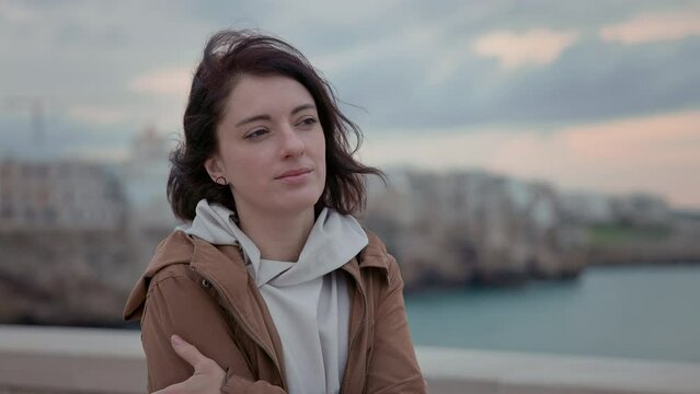 Girl Stands Near Bridge. She Looks Out To Sea. Romantic Image.