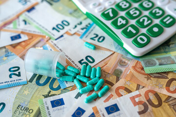 different pills calculator and euro banknotes. medical concept