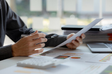 The business man is reviewing a company's financial documents prepared by the Finance Department for a meeting with business partners. Concept of validating the accuracy of financial numbers.