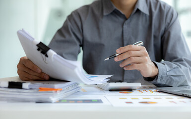 Business man pointing to a chart document showing company financial information, He sits in a private office, a document showing company financial information in chart form. Financial concepts