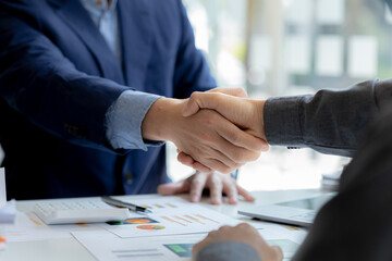 Close-up two business men holding hands, Two businessmen are agreeing on business together and shaking hands after a successful negotiation. Handshaking is a Western greeting or congratulation.