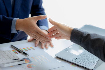 Close-up two business men holding hands, Two businessmen are agreeing on business together and shaking hands after a successful negotiation. Handshaking is a Western greeting or congratulation.