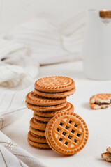 Fototapeta na wymiar Stack of crispy cookies with chocolate filling on a white table.