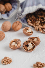 Many walnut kernels in blue eco bag on a white background. Healthy eating concept.