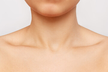 Cropped shot of a young woman's collarbone isolated on a white background. Body care, cosmetology. Soft delicate skin.  Close-up - obrazy, fototapety, plakaty