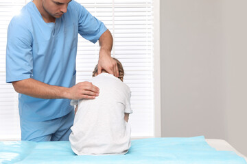 Orthopedist examining child's back in clinic. Scoliosis treatment