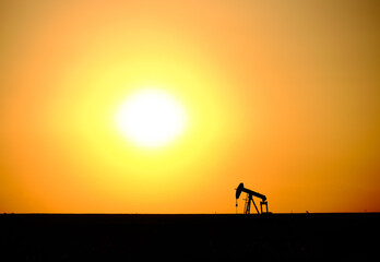 Silhouette of an oil rig at sunset in the Kansas flatlands