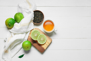 Naklejka na ściany i meble Composition with cup of tea, dried leaves and ripe bergamot fruits on white wooden background