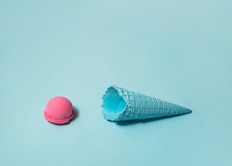 Pastel light blue ice cream cone and pink ice cream ball on blue background. Creative food concept. Minimalistic sweets composition.
