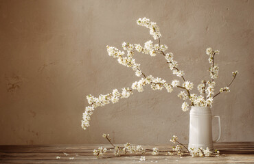 cherry flowers in white jug on old wooden table