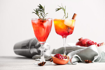 Glasses of tasty pomegranate cocktail on white background