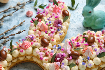 Fototapeta na wymiar Beautiful cake and bunny for Easter celebration on blue background, closeup
