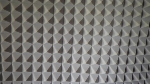 Pyramids of soundproof foam close-up. Noise suppression tool. Gray acoustic foam. Acoustic foam is an open celled foam used for acoustic treatment. It attenuates airborne sound waves.

