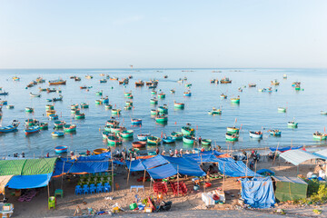 Fototapeta na wymiar Colorful round Vietnamese fishing boats in the sea. locals sell seafood