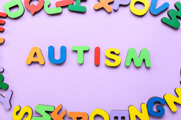 Word AUTISM with colorful letters on lilac background
