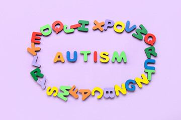 Word AUTISM with colorful letters on lilac background