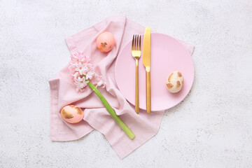 Beautiful table setting with Easter eggs and flowers on white background