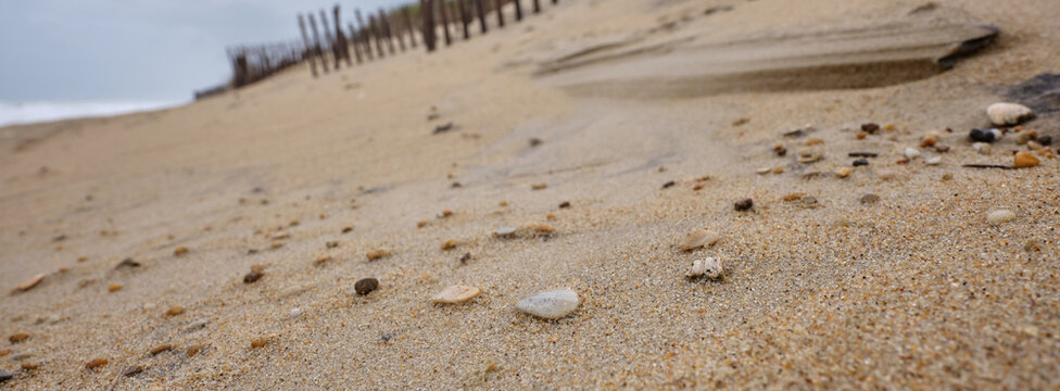 Panoramic image of small surf polished and worn stones on a beach in the Outer Banks of North Carolina