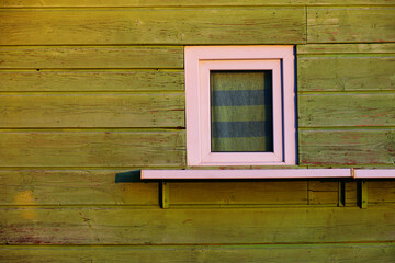 Obraz na płótnie Canvas Old white window on the green wall of a wooden kiosk