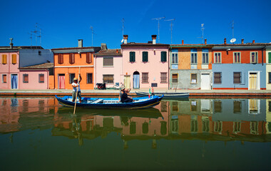 Comacchio prowincja Ferrara, gondola gondolier rejs po kanale, turyści płyną łodzią, włoskie wakacje - obrazy, fototapety, plakaty