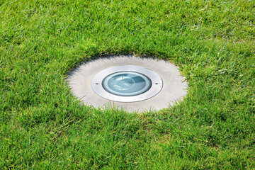 Modern metal spotlight led lamp for outdoor use of circular shape recessed in a grass area