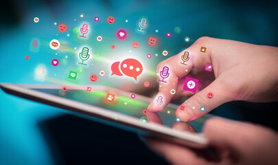 Close-up of a hand using tablet with social media icons