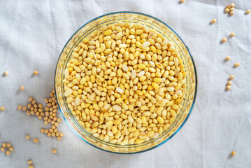 soaked soy bean or soya bean in a glass bowl on fabric background