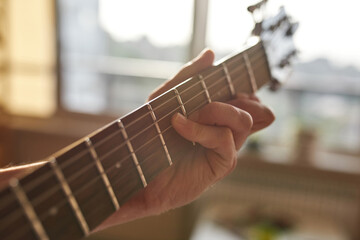 Cropped of man hand play riffs on guitar at home