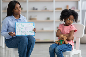 Little african american girl avoiding female child psychologist