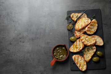 Fototapeta na wymiar Tasty bruschettas with oil, thyme and olives on grey table, flat lay. Space for text