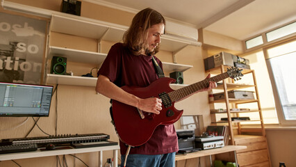 Young rock musician play electric guitar at home