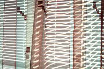 Blinds and a curtain through which light passes.