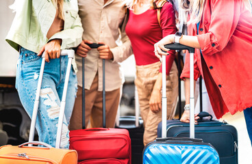 Close up of friends group waiting for train at railway station platform - Travel life style concept with young people relaxing on suitcases luggage - Vivid backlight filter with shallow depth of field - 492411213
