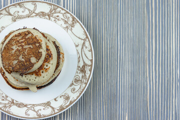 Small pancakes in a plate on the table.
