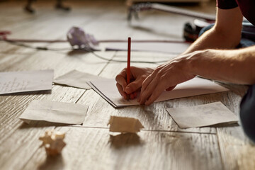 Male songwriter writing text of new song on paper