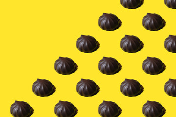 pattern of marshmallows in chocolate. Repeating Chocolate covered marshmallows on yellow background