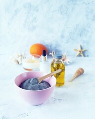 Blue clay, citruses, cream, aromatic oil, healthy tinctures and seashells on a light background,...