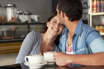 My boyfriend is amazing. Shot of a young couple talking together in a cafe.