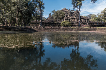 Fototapeta na wymiar Ruins of ancient Khmer temple are reflected in lake still water, Angkor Complex, Siem Reap, Cambodia