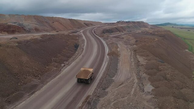 Aerial panoramic view of a coal mining quarry. Heavy mining machinery and dump trucks in a quarry.