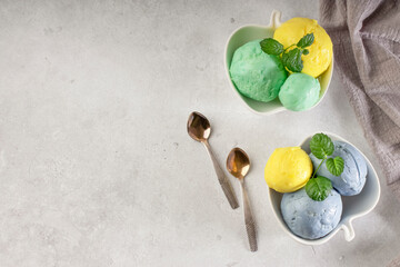 Colorful ice cream balls in white bowls on a light background. Delicious refreshing summer dessert. Homemade natural product. copy space