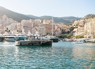 Boat opposite superyachts moored in Monaco harbour on monaco yacht show 