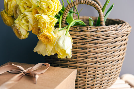 Basket with yellow flowers and gift box, copy space.